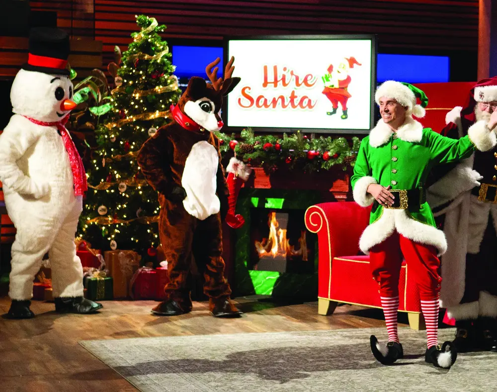 Mitch Allen with holiday characters in a HireSanta display.